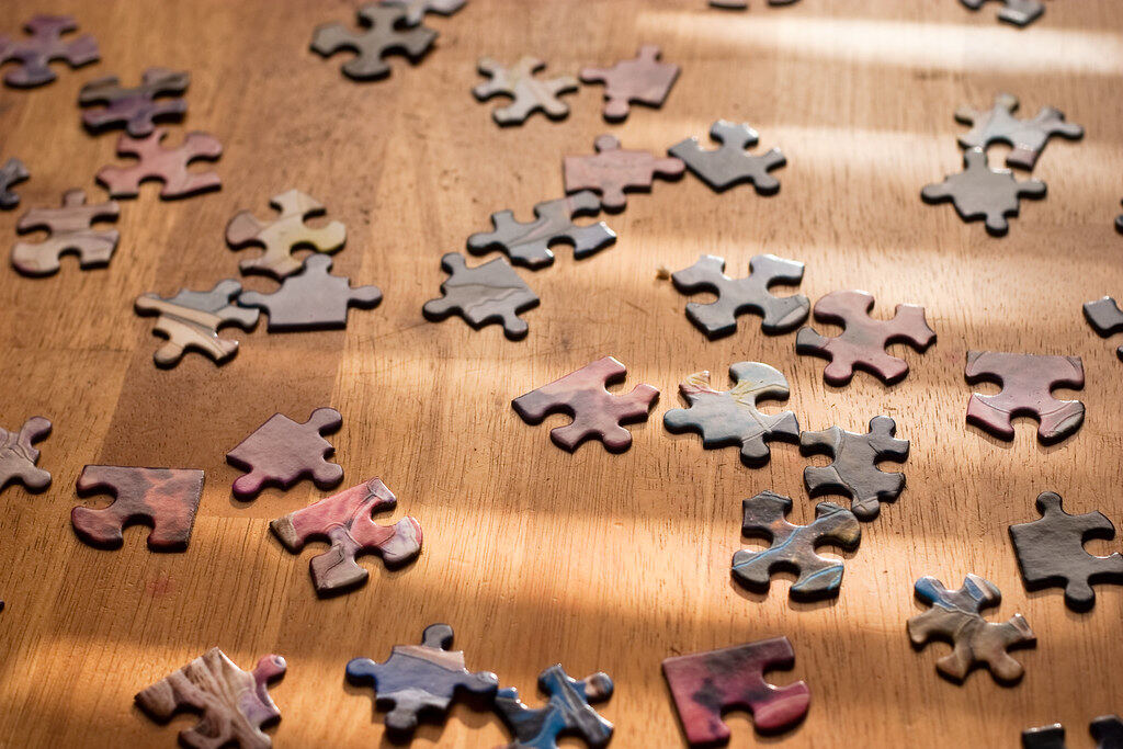 Puzzleteile auf einem Holztisch im Sonnenlicht