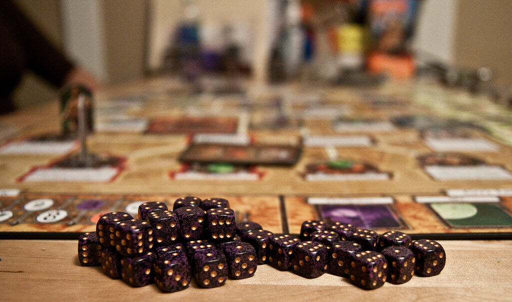 Würfel auf einem Spielbrett bei einem Spieleabend